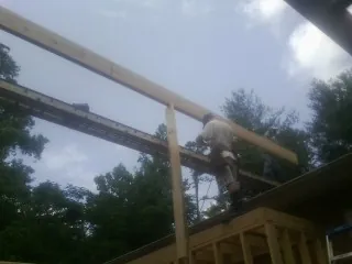 Carpenter setting a ridge beam over a new addition frame — Ice Dam Removal by Roofing Brothers in Beaverton