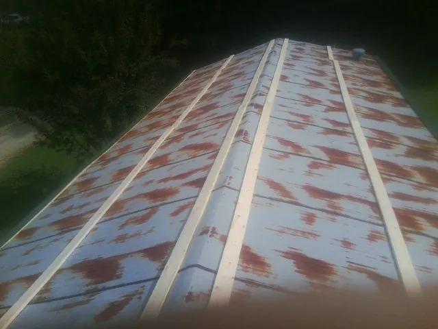 Rusted metal roof panels with new wood purlins before replacement — Storm Damage Roof Repair in Beaverton by Roofing Brothers