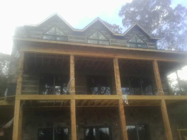 Dormers and porch framing on a large log home under construction — Roof Coating work by our crew in Beaverton